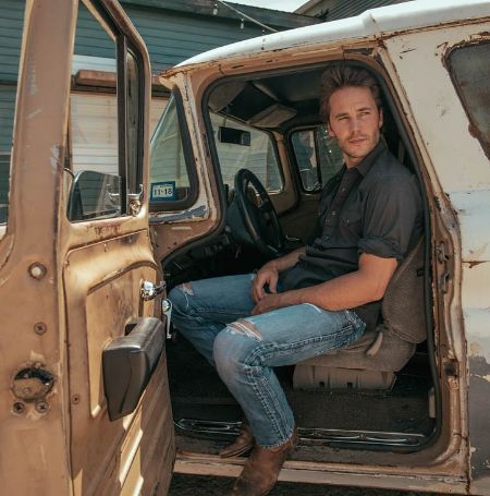 Taylor Kitsch posed in a rundown truck.